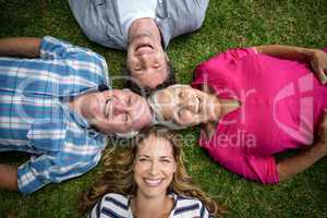 Smiling family lying in the grass