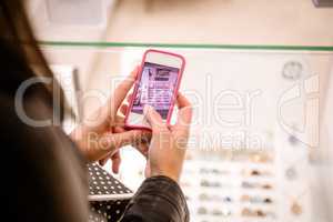 Close-up of womans hand clicking a photo of shop display