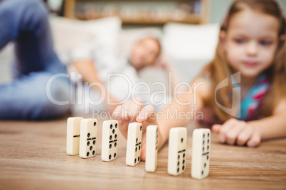Girl arranging domino on floor