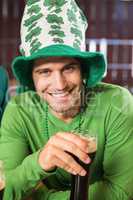 Smiling man with a hat toasting a beer
