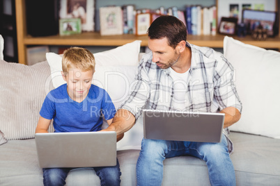 Man and son working on laptop