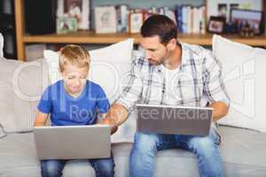 Man and son working on laptop