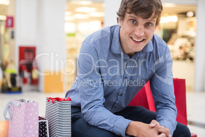 Happy man sitting in shopping mall