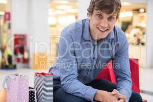 Happy man sitting in shopping mall