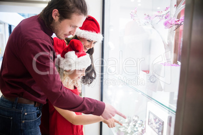 Family in Christmas attire looking at a display of wrist watch