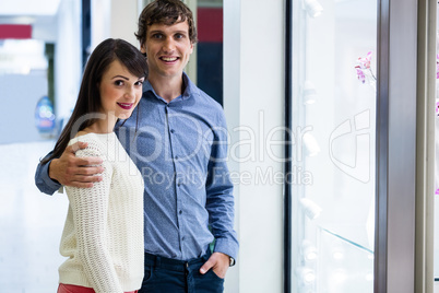 Portrait of couple standing in front of shop display