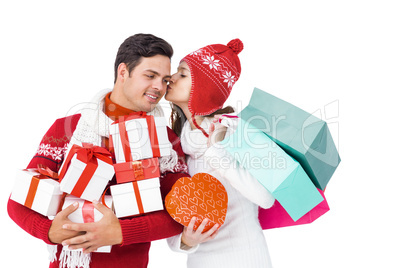 Happy couple with winter clothes holding gift boxes and shopping