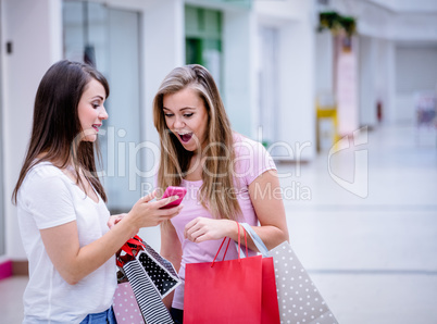 Two beautiful women looking at phone