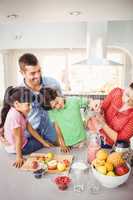 Cheerful family with mother pouring fruit juice in jug