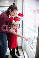 Family in Christmas attire looking at a display of wrist watch