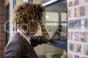 Tired businesswoman leaning on window