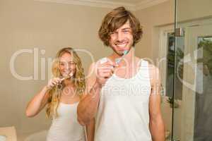 Cute couple brushing their teeth together