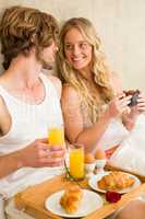 Cute couple having breakfast in bed