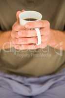 Masculine hands holding a mug of tea