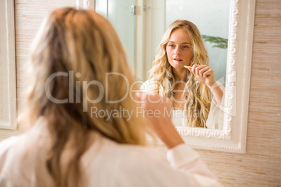 Blonde woman brushing her teeth