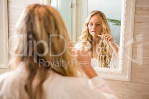 Blonde woman brushing her teeth