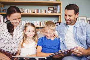 Cheerful family reading book