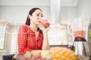 Smiling woman drinking fruit juice