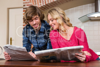 Cute couple reading the newspaper