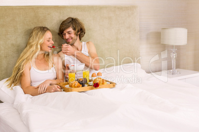 Cute couple having breakfast in bed