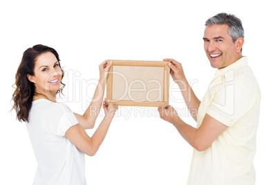 Happy couple holding picture frame