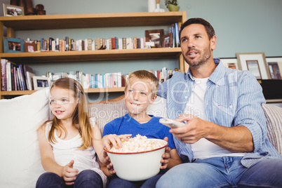 Smiling family with popcorns while watching television