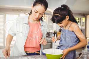 Close-up of woman preparing food with daughter