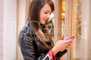 Beautiful woman using a mobile phone outside a shop