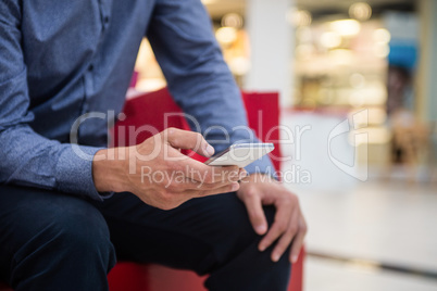 Mid section of man using mobile phone