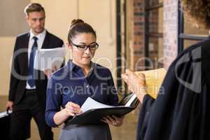 Lawyer looking at documents and interacting with businesswoman