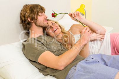 Cute couple cuddling with boyfriend smelling a rose