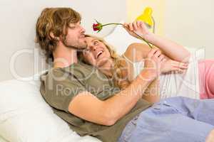 Cute couple cuddling with boyfriend smelling a rose
