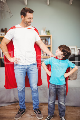 Happy father and son in superhero costume