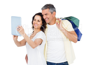 Couple with shopping bags looking at PC tablet
