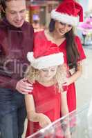 Family in Christmas attire looking at a display