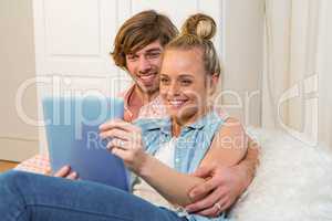 Cute couple using tablet computer on the couch