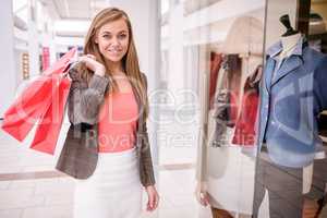 Portrait of woman holding shopping bags in mall