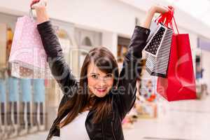 Portrait of excited woman holding shopping bags