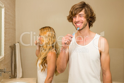 Cute couple brushing their teeth together