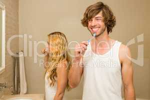 Cute couple brushing their teeth together