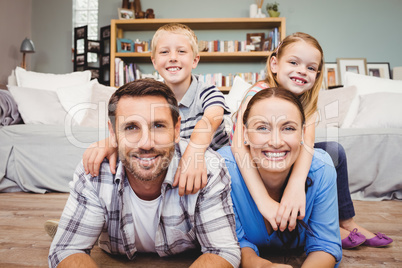 Parents lying on floor while children sitting on their back