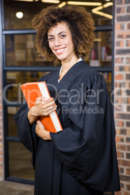 Lawyer standing near library with law book