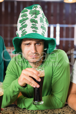 Man with a hat toasting a beer