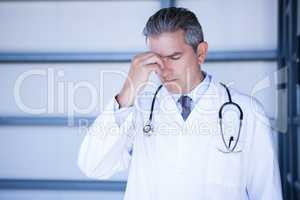 Tensed doctor standing in hospital