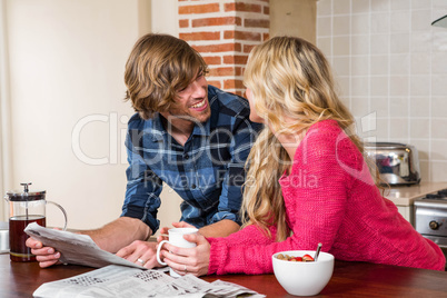 Cute couple reading the newspaper