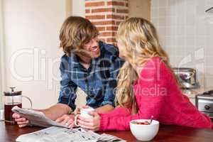 Cute couple reading the newspaper