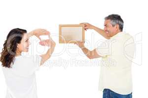 Happy couple holding picture frame