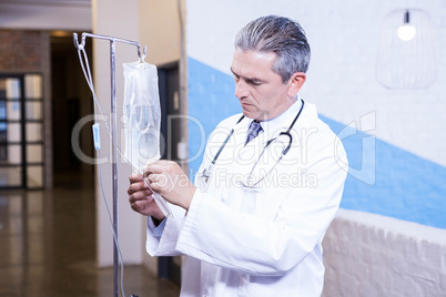Male doctor checking a saline drip