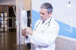 Male doctor checking a saline drip