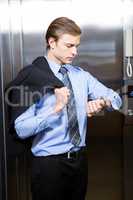 Businessman checking time while waiting for elevator